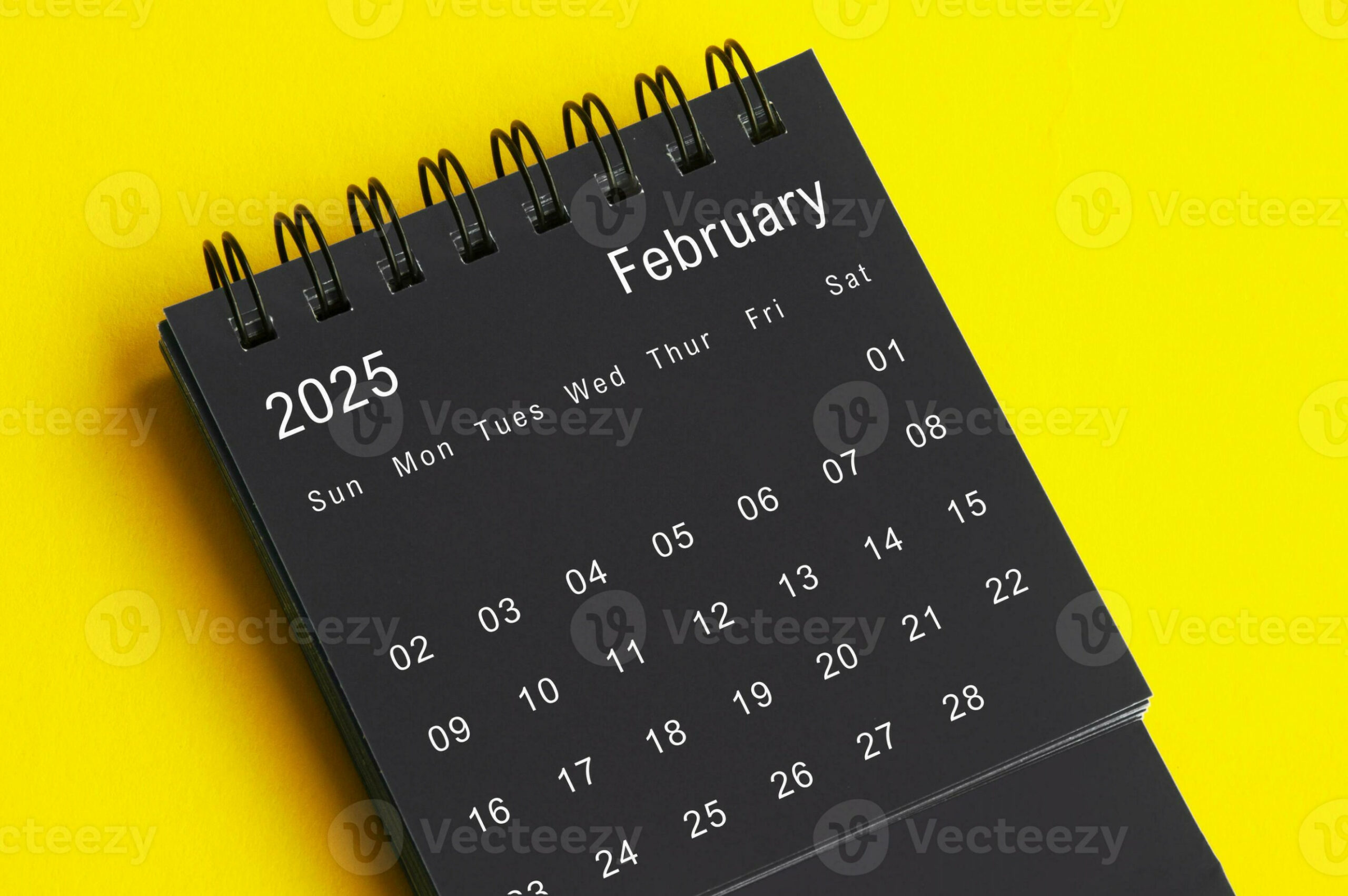 February  black and white desk calendar on yellow cover